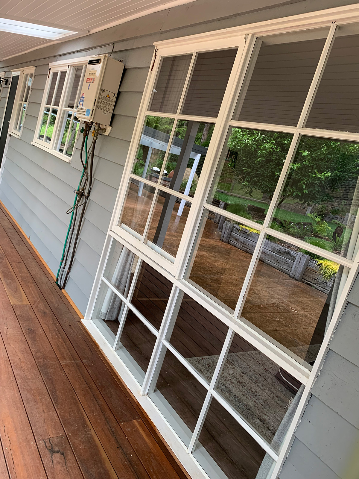 Removed window screens beside windows on a covered verandah