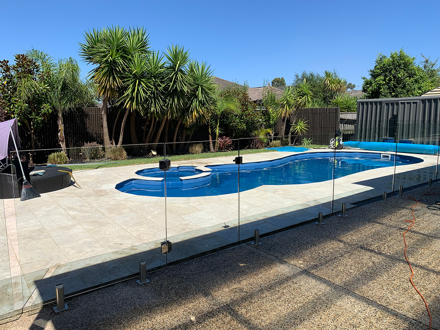 Glass fencing surrounding an outdoor swimming pool